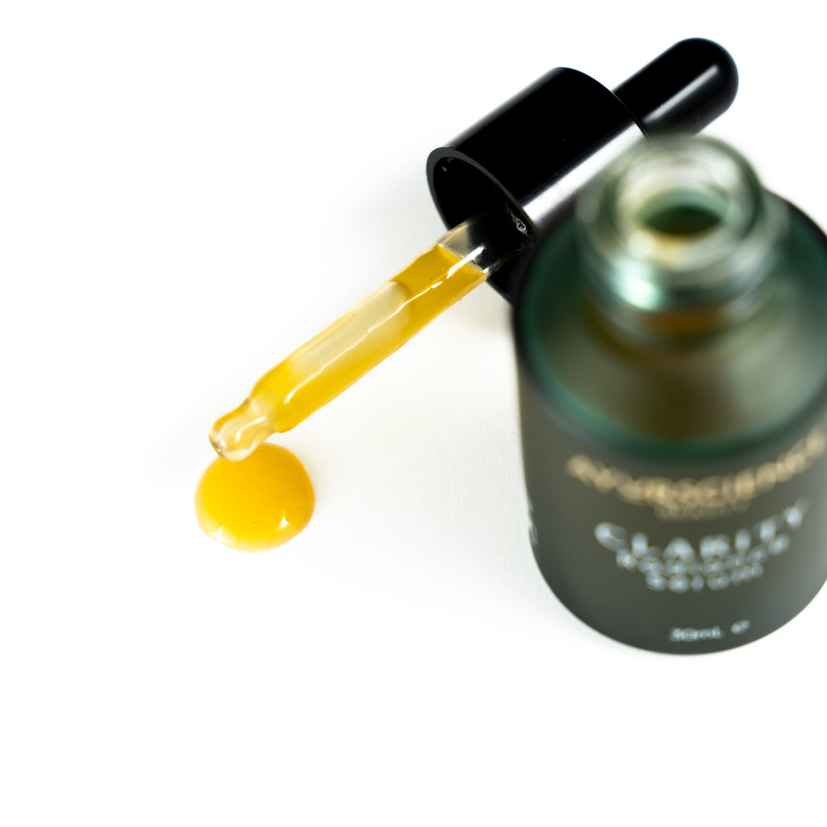 AyurScience Beauty Clarity Serum  open bottle showing a dropper with golden coloured skin serum.